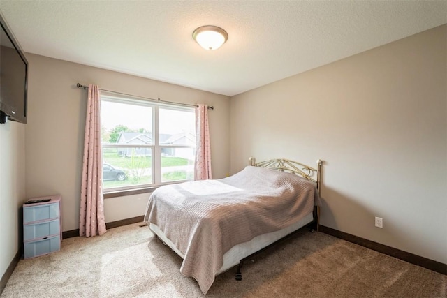 bedroom with light colored carpet and baseboards