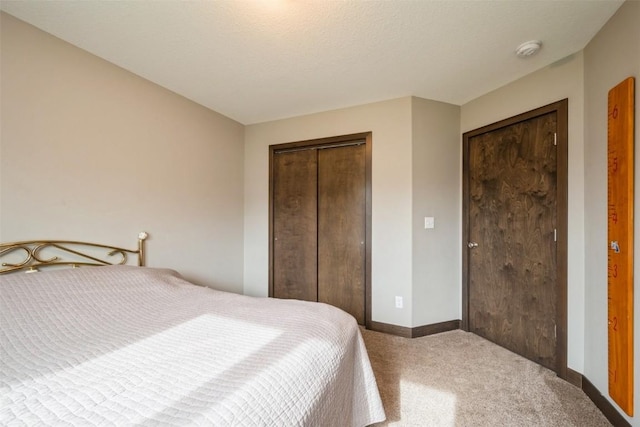 bedroom featuring carpet, a closet, and baseboards
