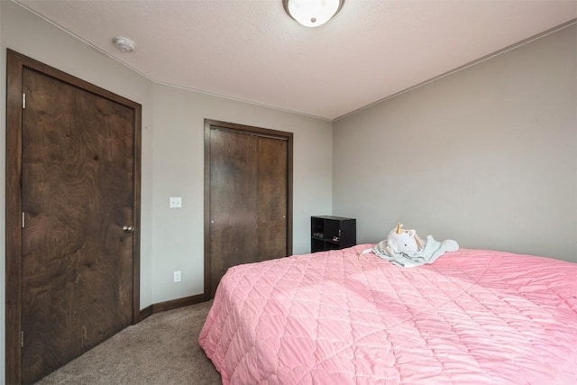 carpeted bedroom with baseboards and a closet