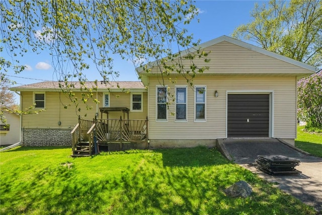 back of property with a lawn, a wooden deck, and an attached garage