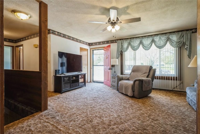 carpeted living area with a ceiling fan and a textured ceiling