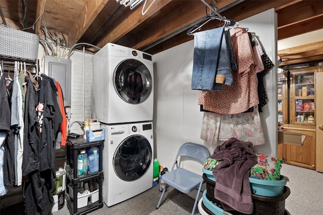 laundry area featuring stacked washer / drying machine, carpet, and electric panel