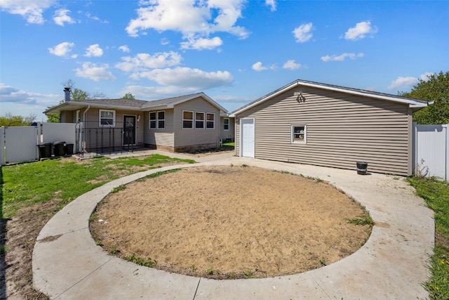 rear view of property featuring fence and a gate