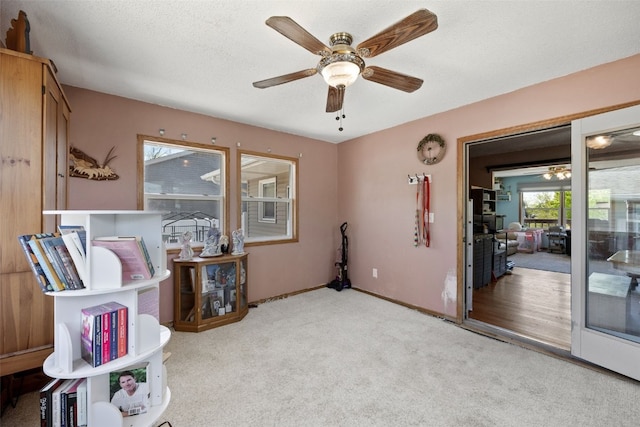 living area featuring a ceiling fan, carpet flooring, and baseboards