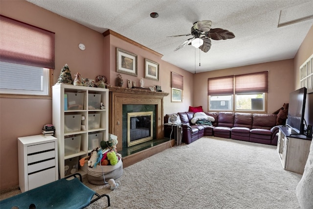 carpeted living area featuring a fireplace, a ceiling fan, and a textured ceiling