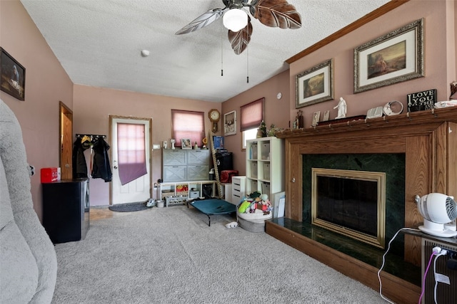 living area featuring carpet flooring, a premium fireplace, ceiling fan, and a textured ceiling