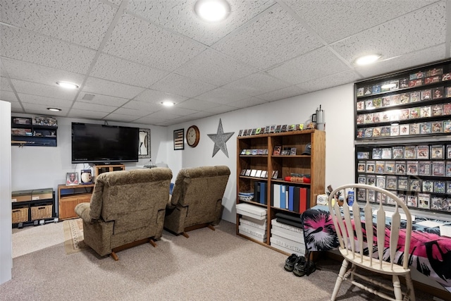 carpeted living area featuring a paneled ceiling
