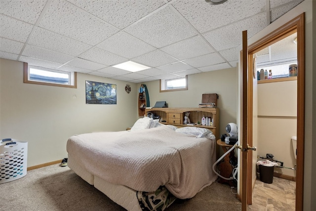 bedroom featuring carpet floors, a paneled ceiling, and baseboards