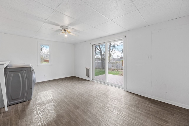 300 SW Palisades Rd, Mount Vernon, IA 52314 - unfurnished living room with a drop ceiling, wood finished floors, ceiling fan, baseboards, and washer / clothes dryer
