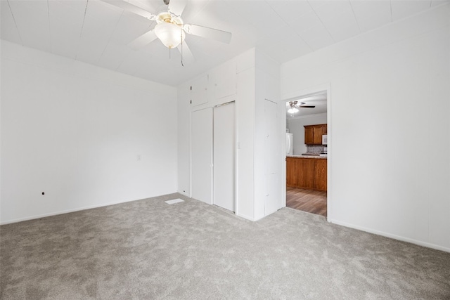 300 SW Palisades Rd, Mount Vernon, IA 52314 - unfurnished bedroom with carpet floors, ceiling fan, a closet, and freestanding refrigerator