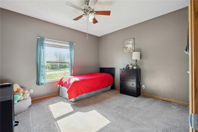 carpeted bedroom featuring baseboards and ceiling fan