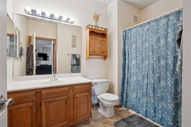 bathroom featuring tile patterned flooring, toilet, vanity, and a shower with shower curtain