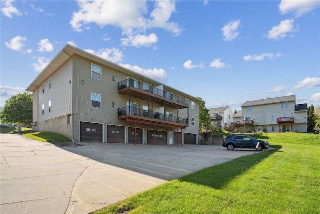 view of property with driveway, an attached garage, and a residential view
