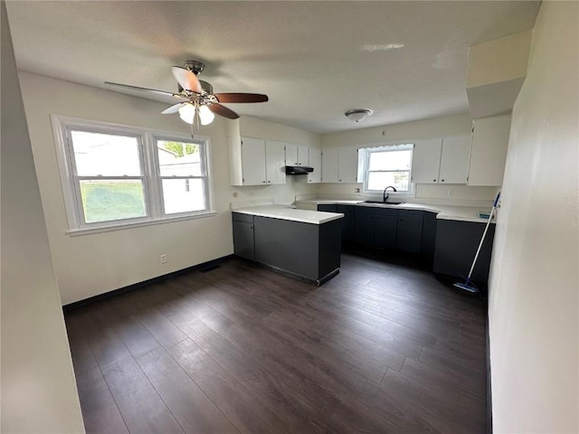 2770 24th Ave, Marion, IA 52302 - kitchen with under cabinet range hood, a ceiling fan, light countertops, dark wood-style flooring, and a peninsula