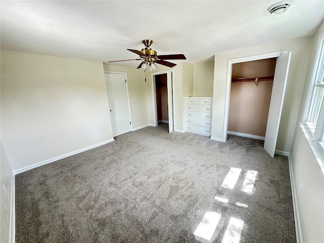 2770 24th Ave, Marion, IA 52302 - unfurnished bedroom with carpet flooring, multiple closets, a textured ceiling, and a ceiling fan
