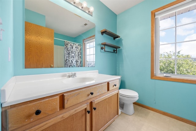 full bath with toilet, vanity, baseboards, and curtained shower