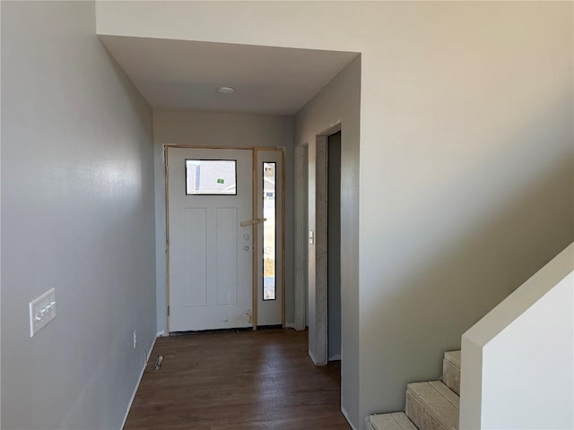 entryway with dark wood-style flooring, stairs, and baseboards