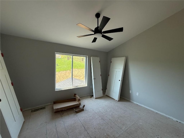 unfurnished bedroom featuring lofted ceiling, baseboards, and a ceiling fan