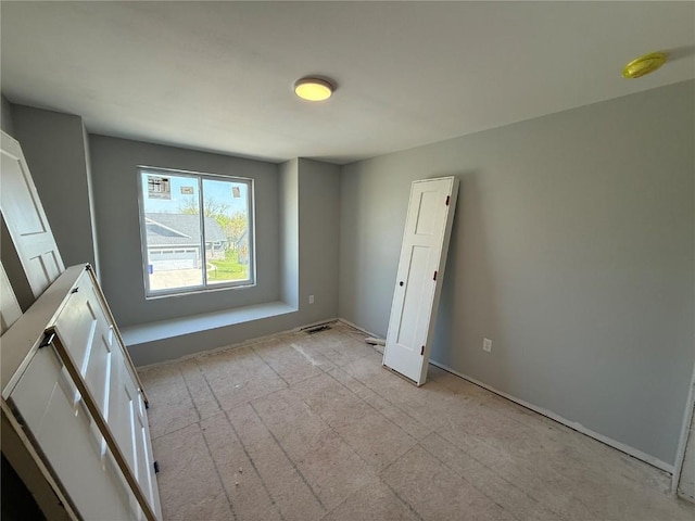empty room with baseboards and a smoke detector