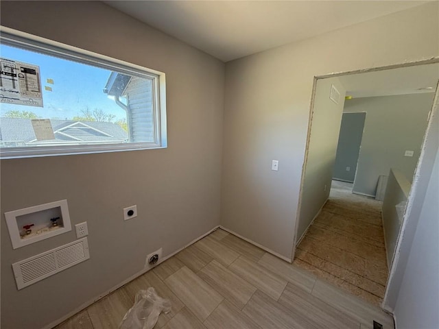 washroom with hookup for an electric dryer, hookup for a washing machine, and baseboards