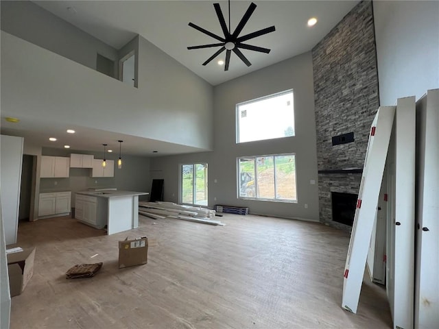 1301 Legend Dr, Tiffin, IA 52340 - unfurnished living room featuring high vaulted ceiling, a fireplace, light wood-type flooring, a ceiling fan, and recessed lighting