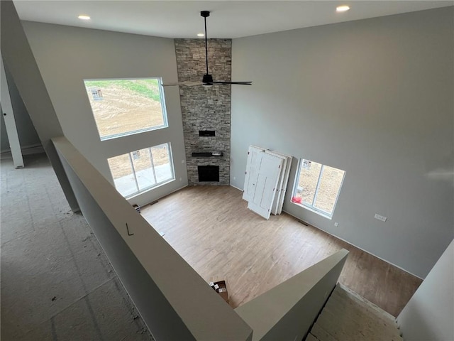 1301 Legend Dr, Tiffin, IA 52340 - unfurnished living room featuring a ceiling fan, recessed lighting, a stone fireplace, and wood finished floors