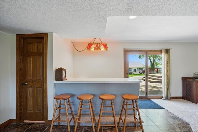 indoor dry bar featuring baseboards, a textured ceiling, and carpet flooring