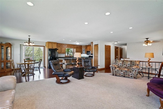living area featuring recessed lighting, a chandelier, a ceiling fan, and dark colored carpet