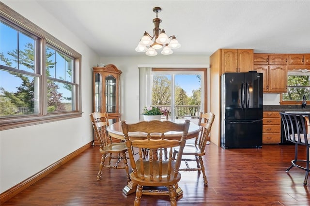 dining space with a chandelier, dark wood-style floors, and baseboards