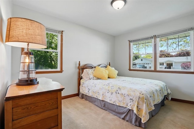 bedroom featuring baseboards and light colored carpet