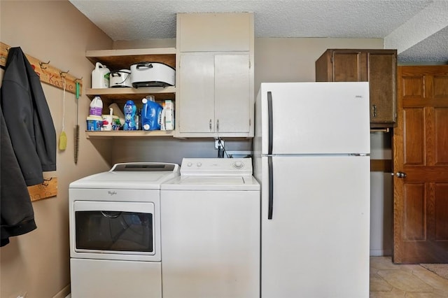 laundry area featuring independent washer and dryer, a textured ceiling, and cabinet space