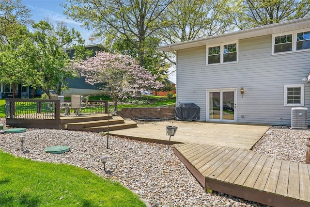 rear view of house featuring a wooden deck and central AC unit