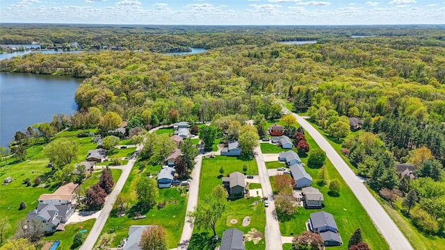 aerial perspective of suburban area with a forest and a nearby body of water