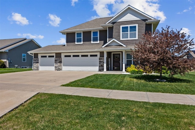 view of front of house featuring driveway, a front lawn, stone siding, and an attached garage