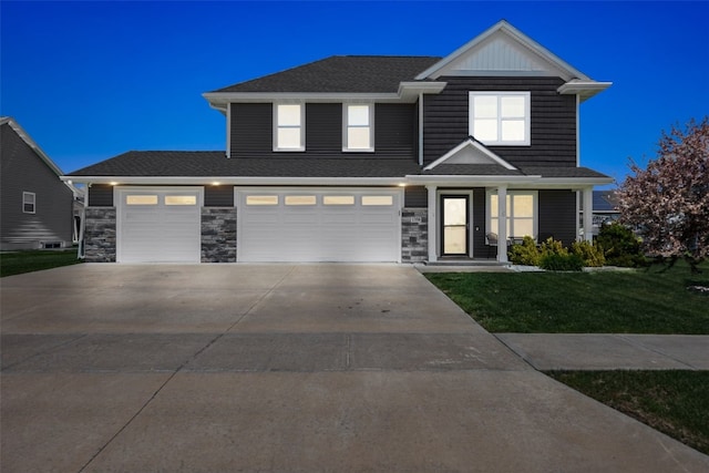 view of front of property with concrete driveway, a front lawn, stone siding, and a garage
