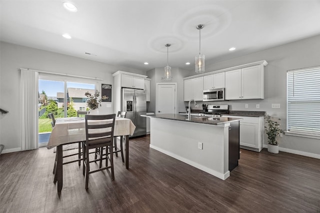 kitchen featuring appliances with stainless steel finishes, dark countertops, a sink, recessed lighting, and dark wood-style flooring