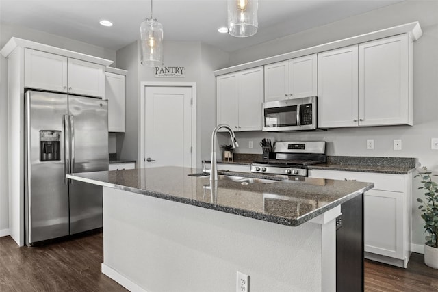 kitchen with appliances with stainless steel finishes, dark wood-style floors, a sink, baseboards, and white cabinetry