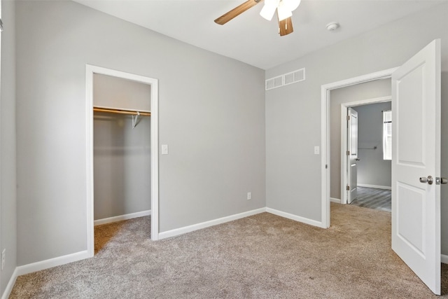 unfurnished bedroom with carpet flooring, baseboards, a closet, ceiling fan, and a spacious closet