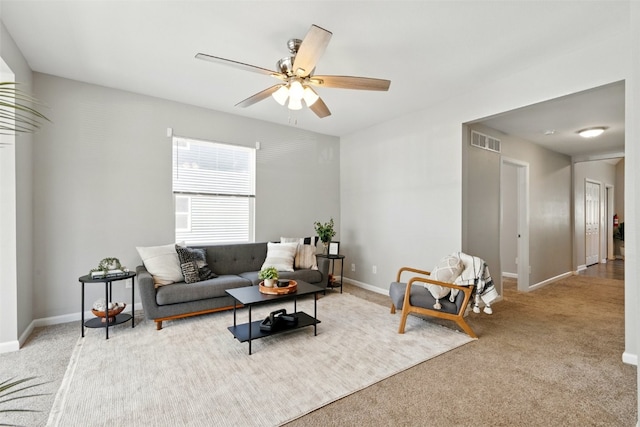 living room featuring light colored carpet, a ceiling fan, and baseboards
