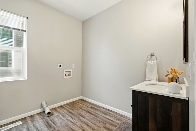 laundry area featuring hookup for an electric dryer, light wood finished floors, baseboards, and hookup for a washing machine
