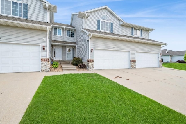 view of front of property featuring driveway, an attached garage, and stone siding