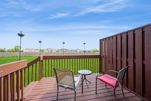 wooden deck featuring a lawn