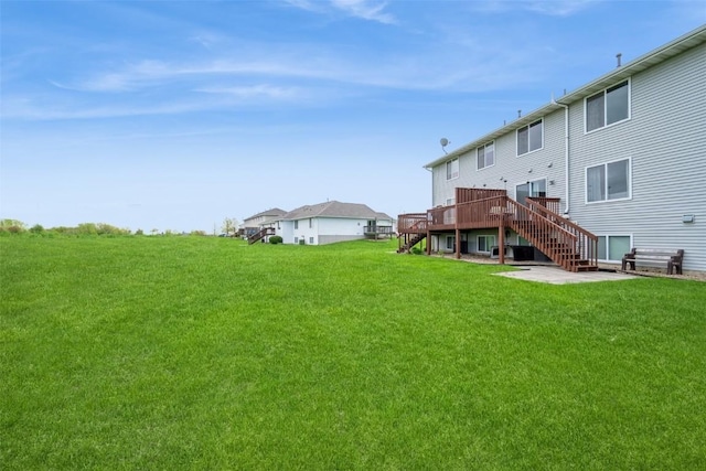 view of green lawn with stairs, a wooden deck, and a patio