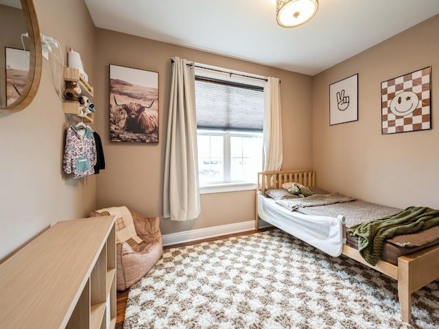bedroom with baseboards and wood finished floors