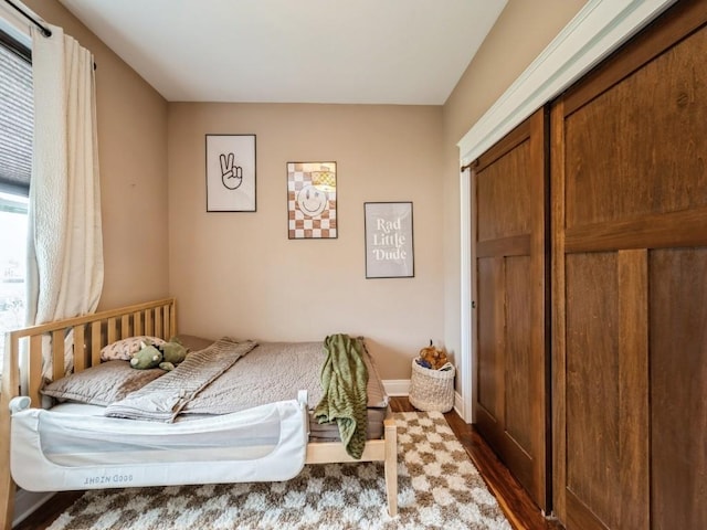 bedroom featuring wood finished floors and baseboards