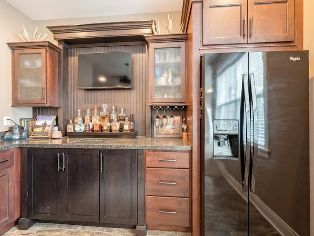 indoor dry bar featuring black refrigerator with ice dispenser