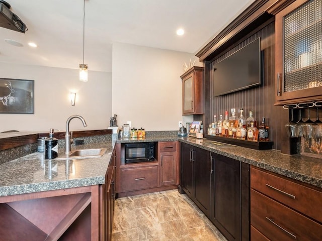 indoor dry bar with black microwave, light marble finish flooring, recessed lighting, and decorative light fixtures