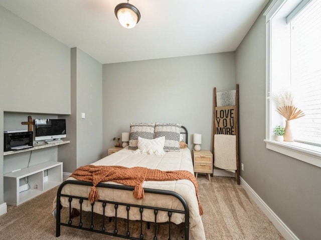 bedroom featuring carpet, multiple windows, and baseboards