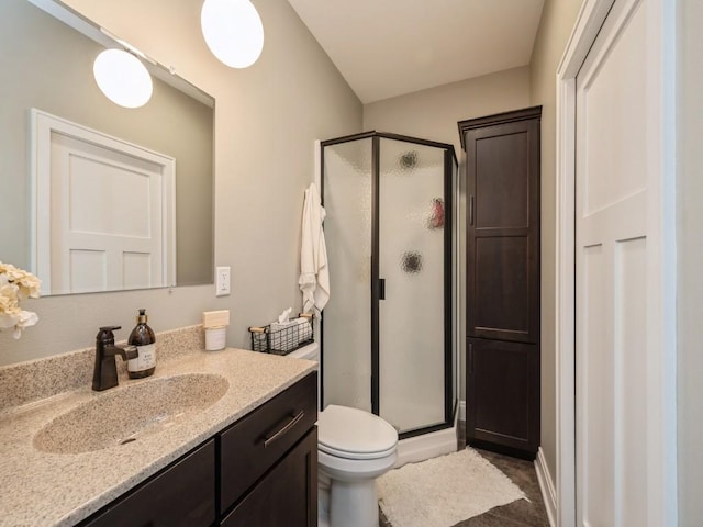 full bath featuring a shower stall, vanity, and toilet