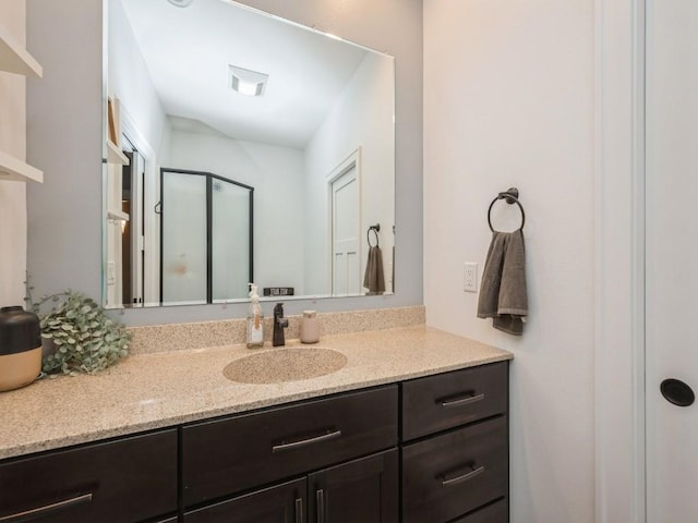 bathroom with vanity and a shower with door